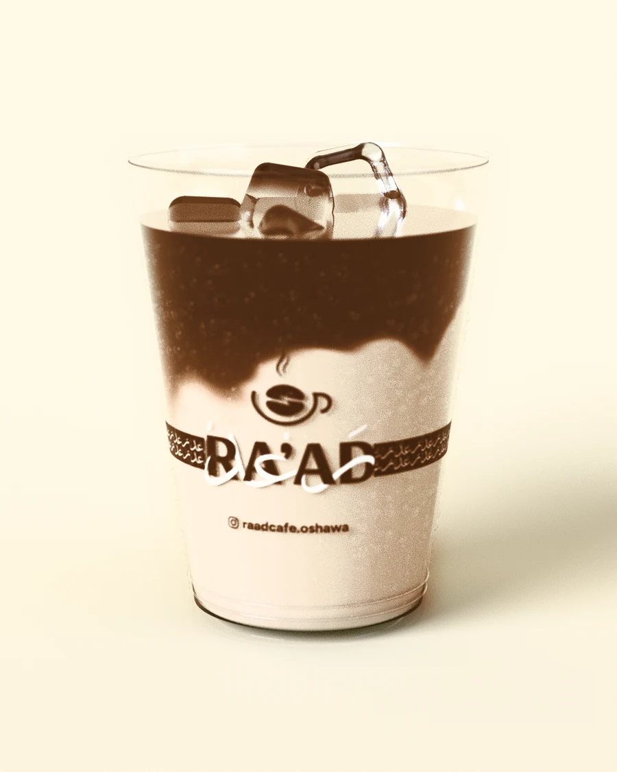 An iced latte in a RA’AD clear cup, espresso settling into the milk over ice